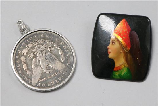 A USSR brooch and a mounted 1886 US one dollar.